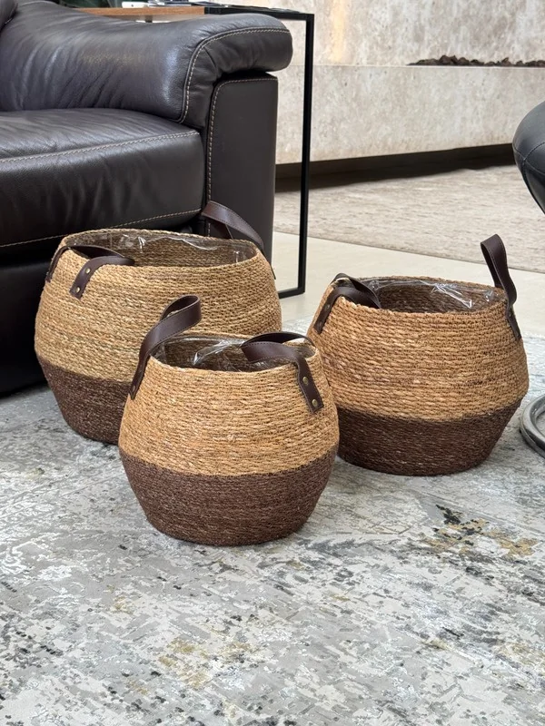 Trio de cachepôs de fibra natural com alças, em uma sala de estar