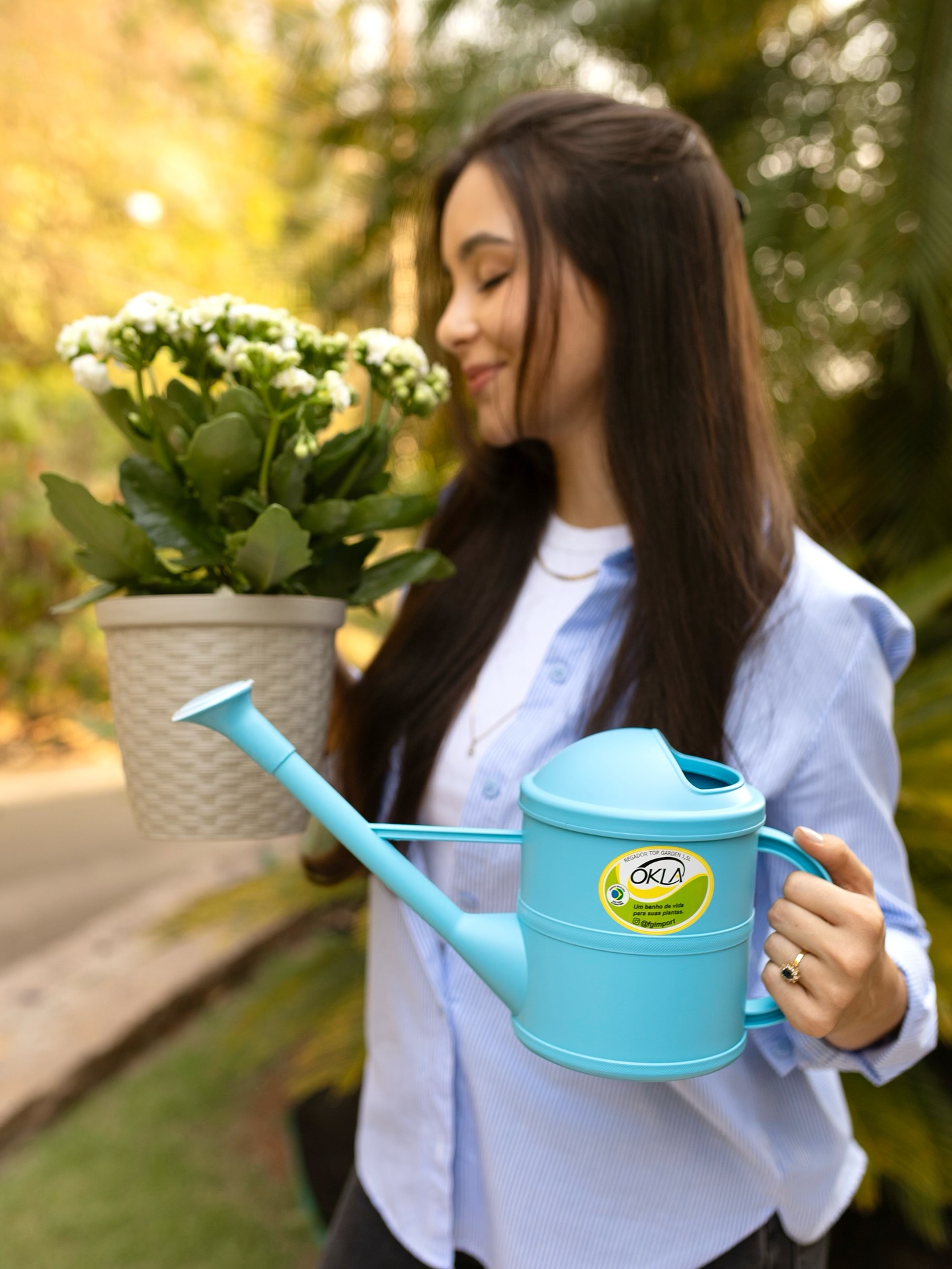Lojista com produtos e regador OKLA da FG